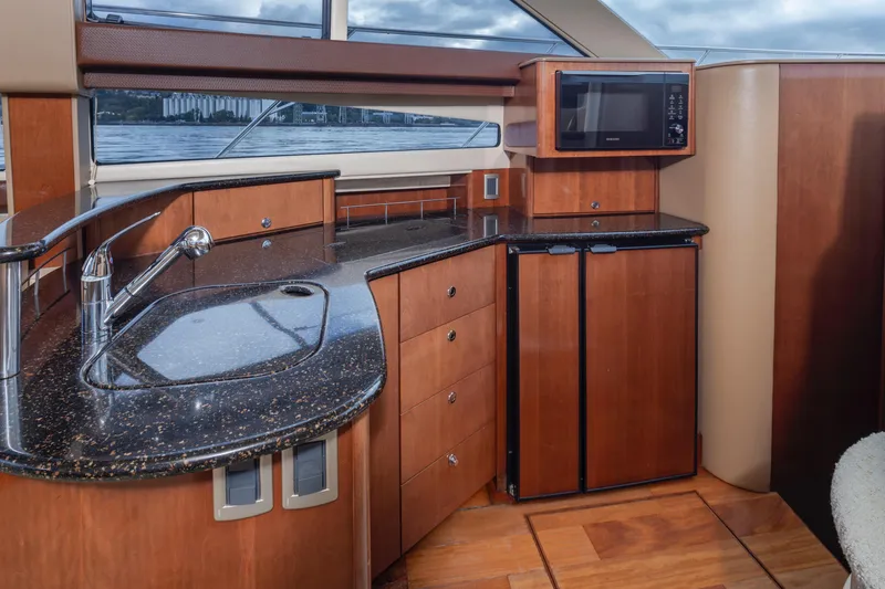 Slide: The Image of 2008 Meridian 391 Sedan yacht interior with modern kitchen, granite countertops, and wooden cabinetry. - 21