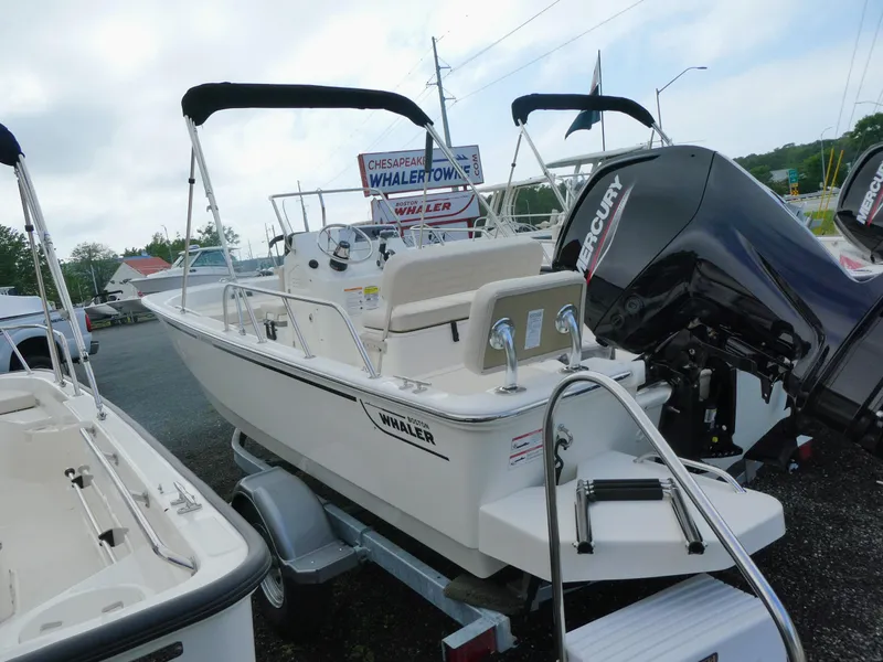Slide: The Image of 2025 Boston Whaler 170 Montauk boat with Mercury engine on display at dealership. - 2