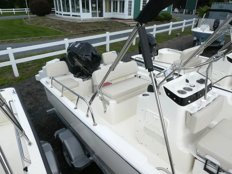 Slide: The Image of 2025 Boston Whaler 170 Montauk boat with seating and controls, parked outdoors. - 4