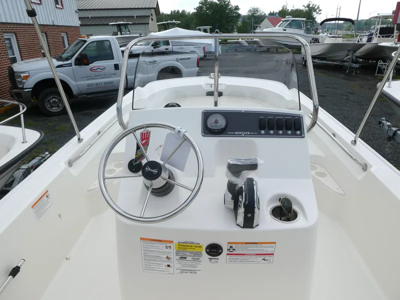 Slide: The Image of 2025 Boston Whaler 170 Montauk boat console with steering wheel and controls. - 5