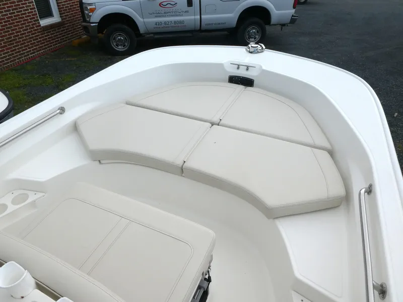 Slide: The Image of 2025 Boston Whaler 170 Montauk boat interior with cushioned seating in a white finish. - 6