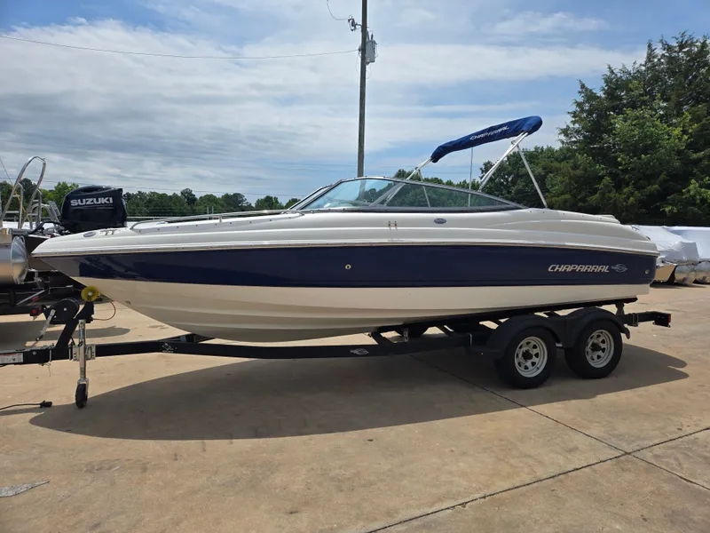 Slide: The Image of 2007 Chaparral 210 SSi boat on trailer with blue canopy, parked outdoors. - 2
