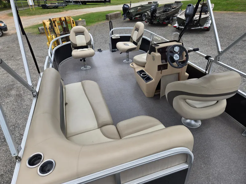 Slide: The Image of 2016 Sun Tracker Bass Buggy 18 DLX pontoon boat interior with beige seating and steering console. - 10