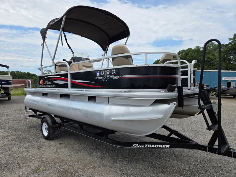 Slide: The Image of 2016 Sun Tracker Bass Buggy 18 DLX pontoon boat on trailer, parked outdoors. - 3