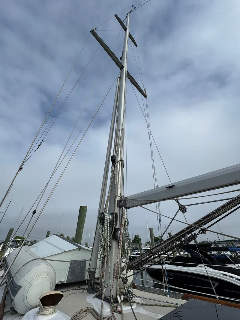 Slide: The Image of Sailboat mast of a 1982 Passport 40 under cloudy skies at a marina. - 10