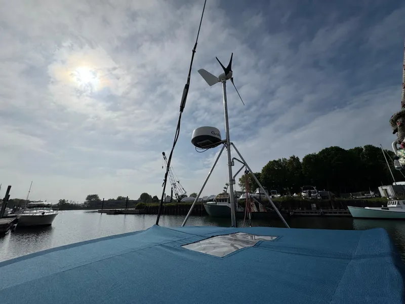 Slide: The Image of Sailboat deck with wind turbine under cloudy sky, Passport 40, 1982 model. - 12