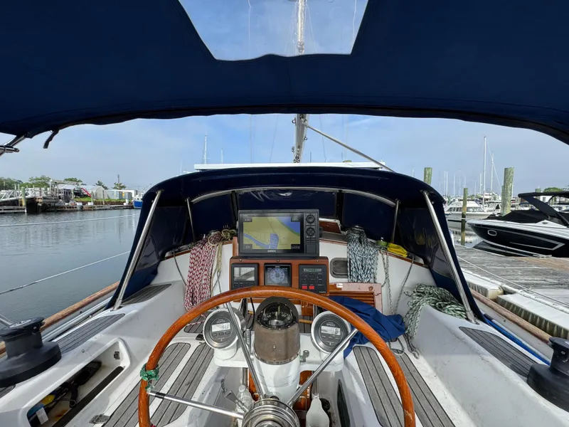Slide: The Image of Cockpit of 1982 Passport 40 sailboat with navigation equipment and wooden steering wheel. - 16
