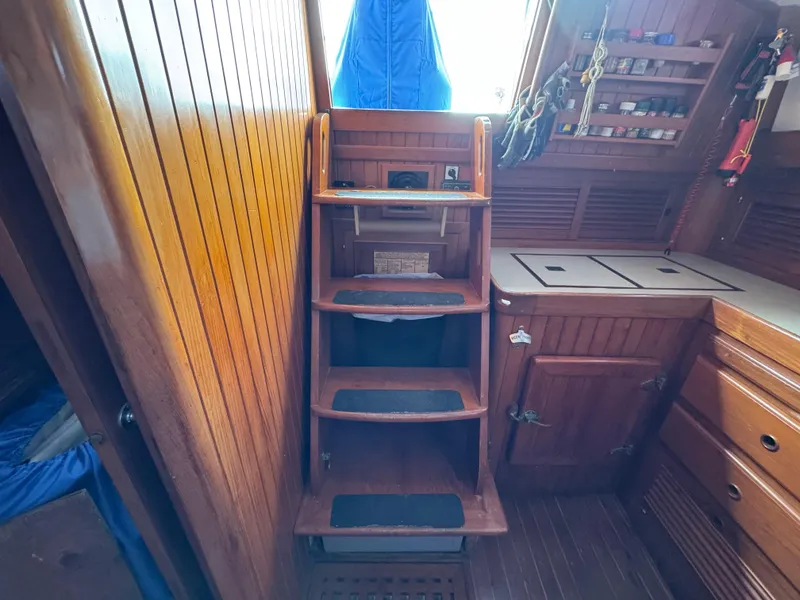 Slide: The Image of Wooden interior of a 1982 Passport 40 sailboat with steps and storage cabinets. - 20