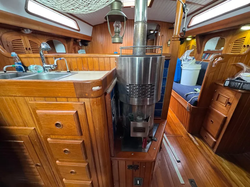 Slide: The Image of Interior of a 1982 Passport 40 sailboat with wooden cabinetry and a stainless steel stove. - 23
