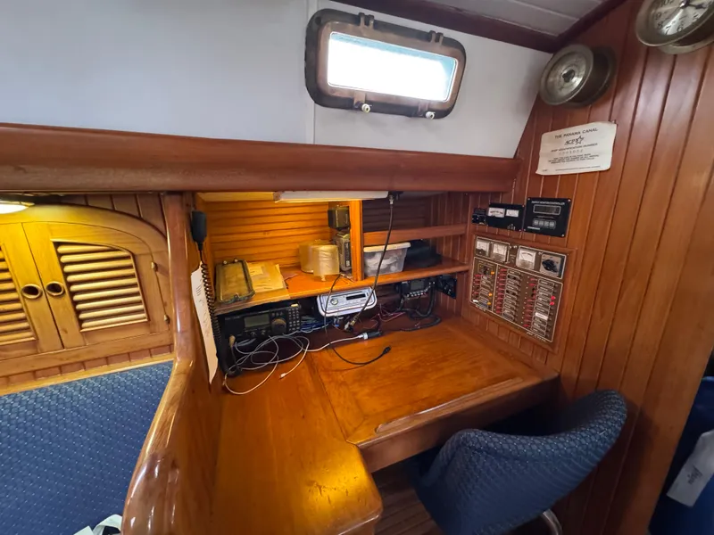 Slide: The Image of Navigation station on a 1982 Passport 40 sailboat with wooden interior and communication equipment. - 29
