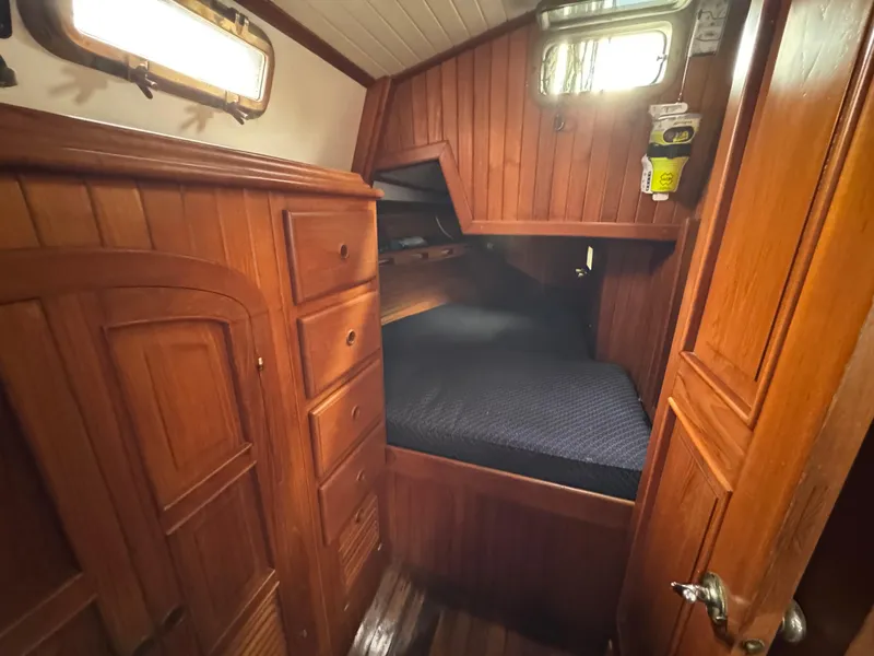 Slide: The Image of Cozy wooden cabin interior of 1982 Passport 40 sailboat with bed and storage. - 30