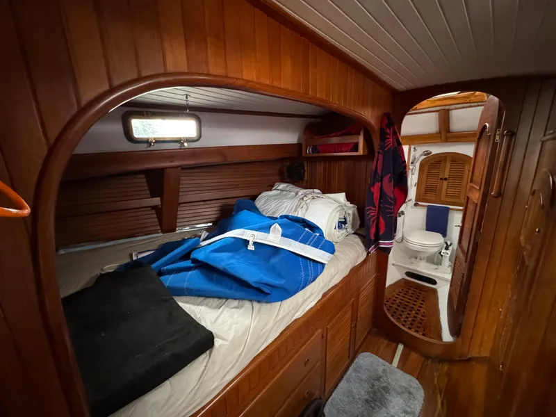 Slide: The Image of Cozy cabin interior of 1982 Passport 40 sailboat with wooden paneling and compact amenities. - 32