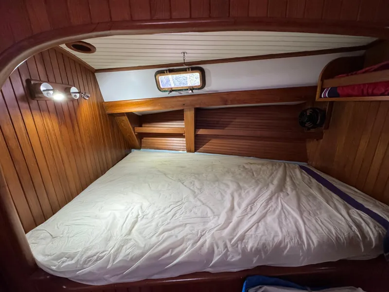 Slide: The Image of Cozy wooden cabin interior of 1982 Passport 40 sailboat with bed and porthole window. - 33
