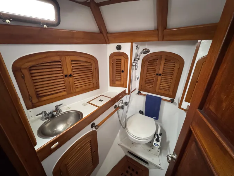 Slide: The Image of 1982 Passport 40 yacht bathroom with wooden cabinets, sink, and toilet. - 35