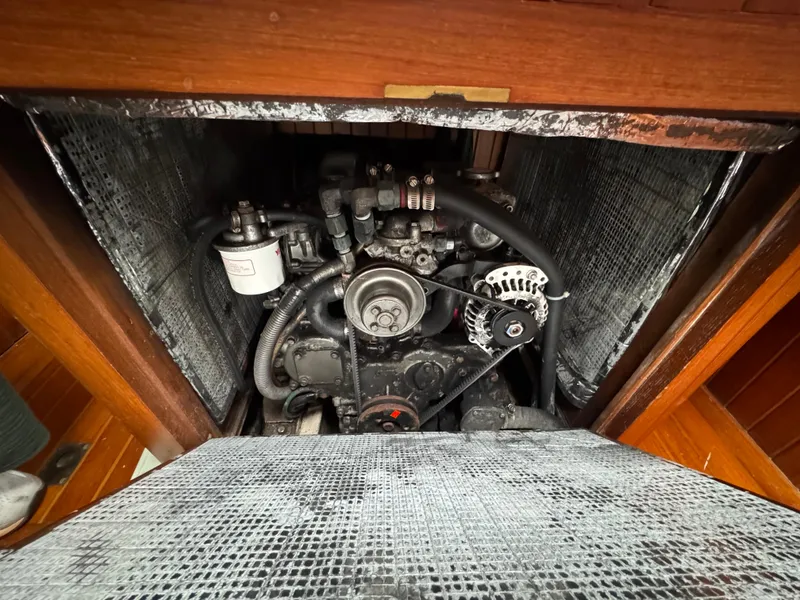 Slide: The Image of Engine compartment of a 1982 Passport 40 sailboat, showcasing mechanical components and wiring. - 37
