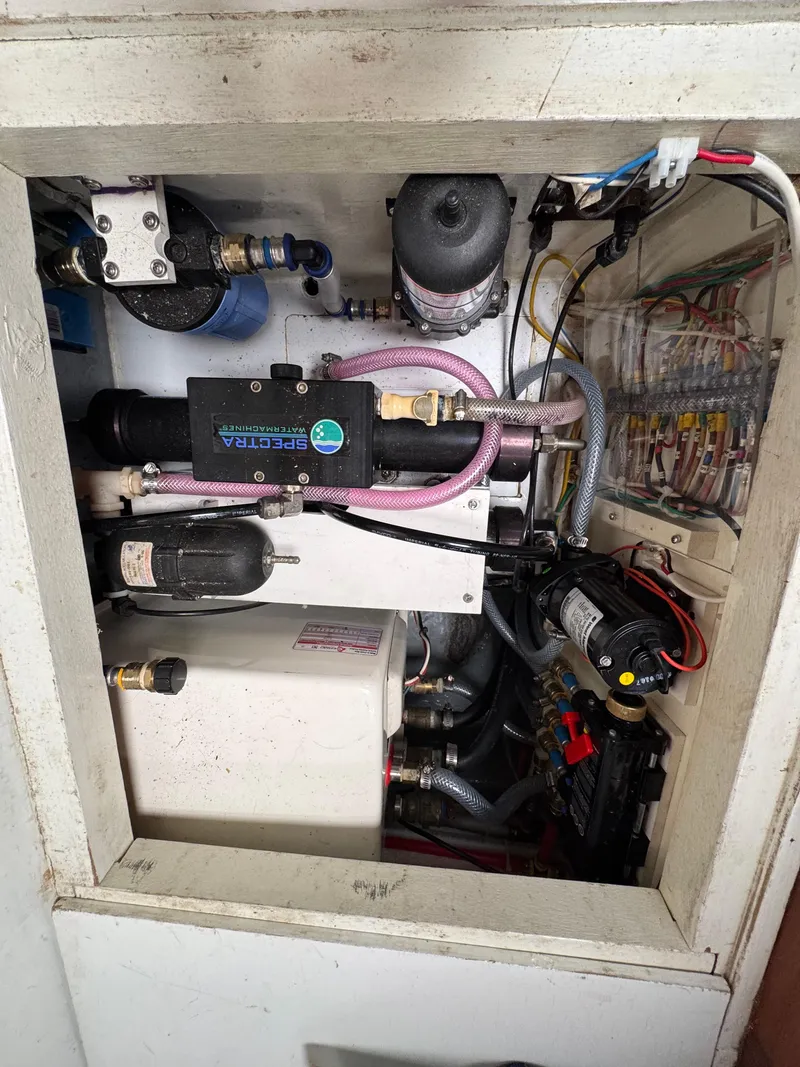 Slide: The Image of Engine compartment of a 1982 Passport 40 sailboat, showcasing mechanical components and wiring. - 38