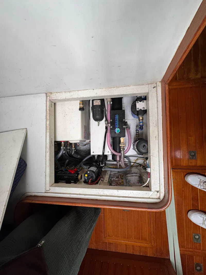 Slide: The Image of Engine compartment of a 1982 Passport 40 sailboat, showcasing mechanical components and wiring. - 39