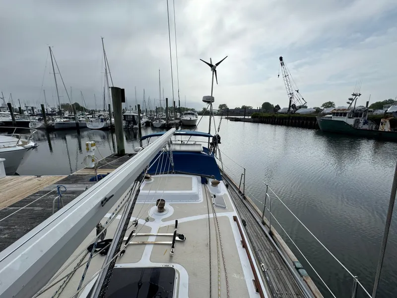 Slide: The Image of Sailboat docked in marina, Passport 40 model, 1982, with overcast sky and calm water. - 6