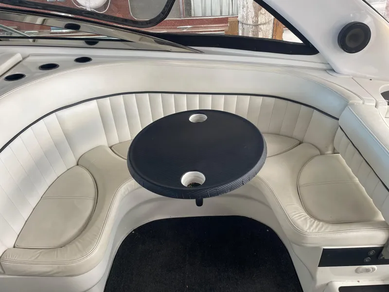 Slide: The Image of 2004 Cobalt 360 boat interior with white leather seating and a black table. - 11