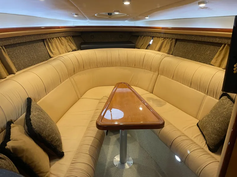 Slide: The Image of Luxurious interior of a 2004 Cobalt 360 boat with beige seating and wooden table. - 16
