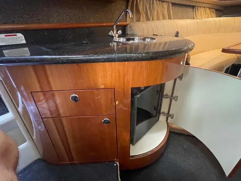 Slide: The Image of 2004 Cobalt 360 yacht interior with wooden cabinetry, sink, and open storage compartment. - 19