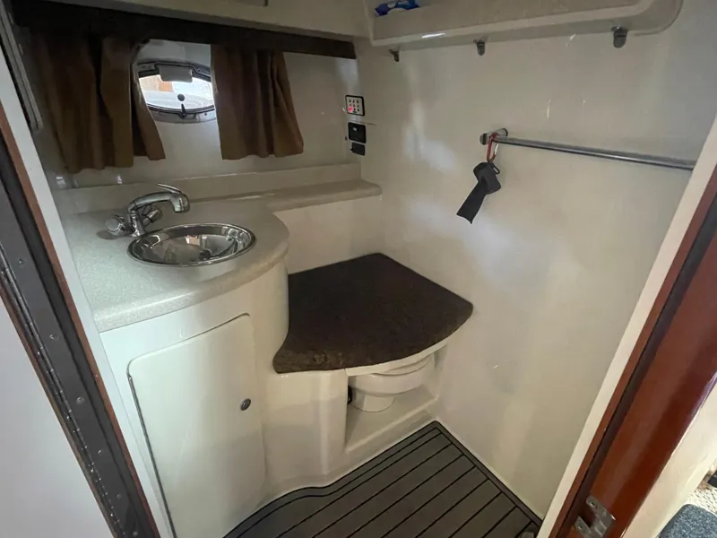 Slide: The Image of Compact bathroom in a 2004 Cobalt 360 boat with sink, countertop, and window. - 23
