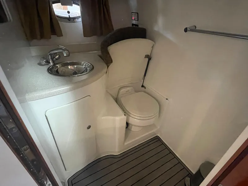 Slide: The Image of 2004 Cobalt 360 boat bathroom with sink, toilet, and wooden floor. - 24
