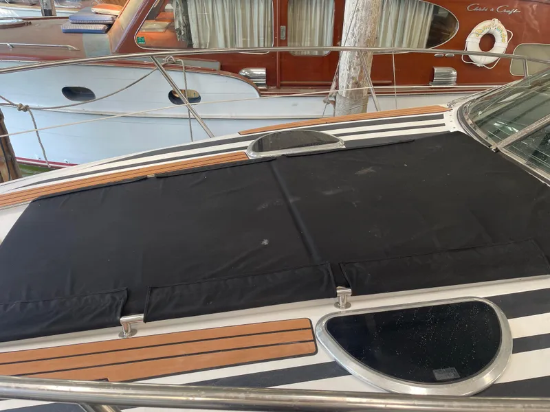 Slide: The Image of 2004 Cobalt 360 boat deck with black cover and wooden accents. - 34
