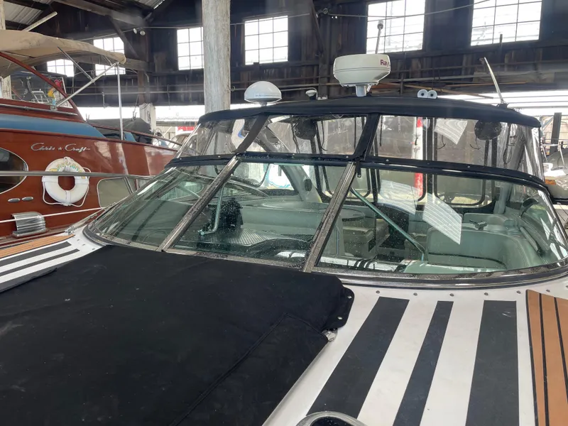 Slide: The Image of 2004 Cobalt 360 boat in a marina, featuring a sleek design and covered cockpit. - 35