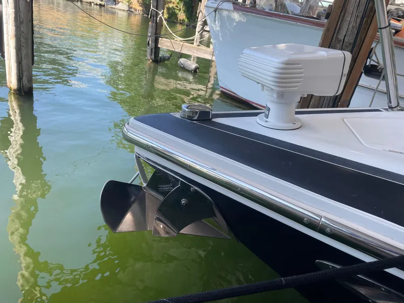 Slide: The Image of 2004 Cobalt 360 boat docked, featuring a propeller and radar, on calm green water. - 37