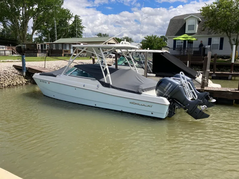 Slide: The Image of 2022 World Cat 230 SD boat docked in a marina, featuring dual outboard motors. - 11