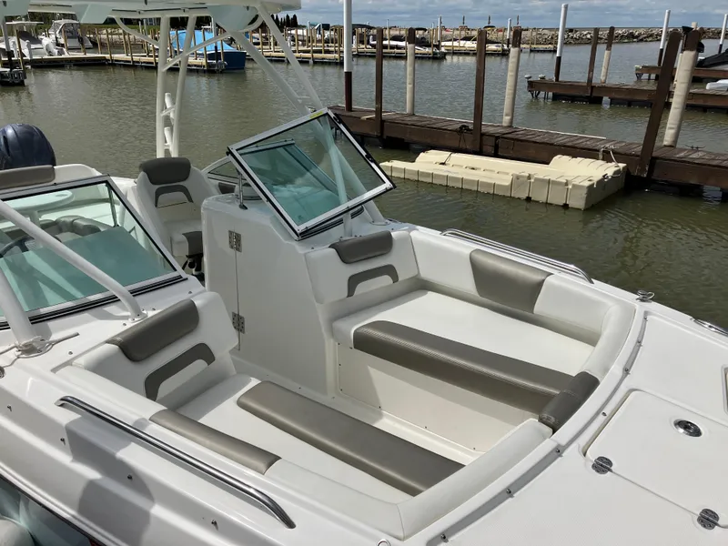 Slide: The Image of 2022 World Cat 230 SD boat interior with seating, docked at marina. - 17