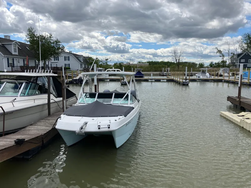 Slide: The Image of 2022 World Cat 230 SD boat docked in a marina under cloudy skies. - 2