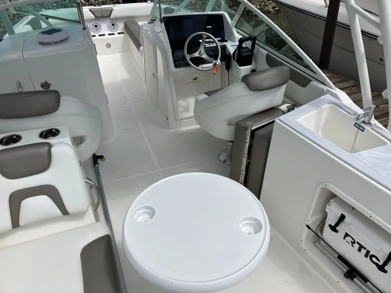 Slide: The Image of 2022 World Cat 230 SD boat interior with seating, steering wheel, and table. - 21