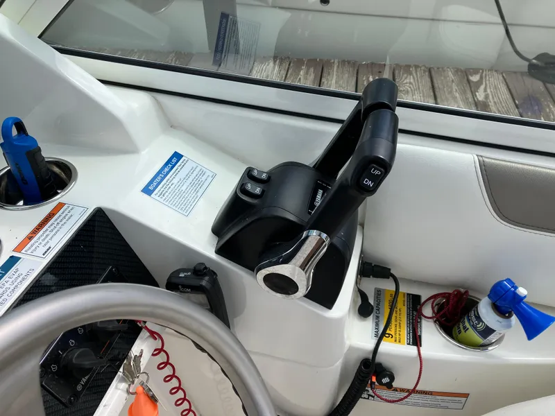 Slide: The Image of Control panel of a 2022 World Cat 230 SD boat with steering wheel and throttle. - 29