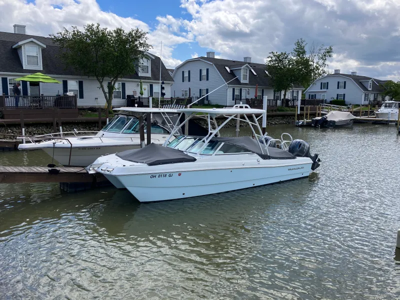 Slide: The Image of 2022 World Cat 230 SD boat docked in a residential canal setting. - 8