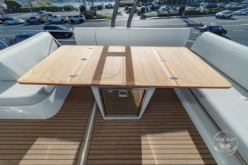 Slide: The Image of Prestige F4.3 2026 yacht deck with wooden table and cushioned seating. - 18