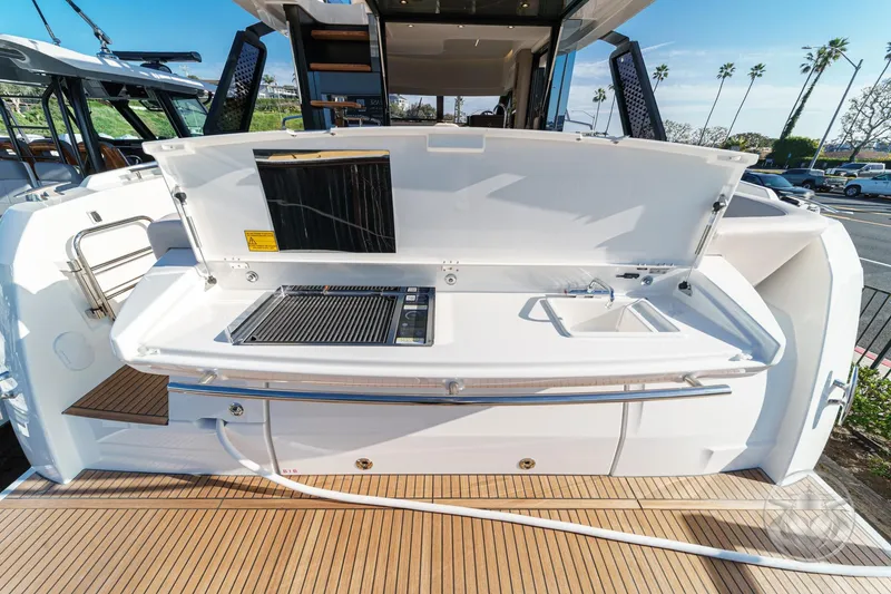 Slide: The Image of Outdoor kitchen on 2026 Prestige F4.3 yacht with grill and sink, docked under clear skies. - 20