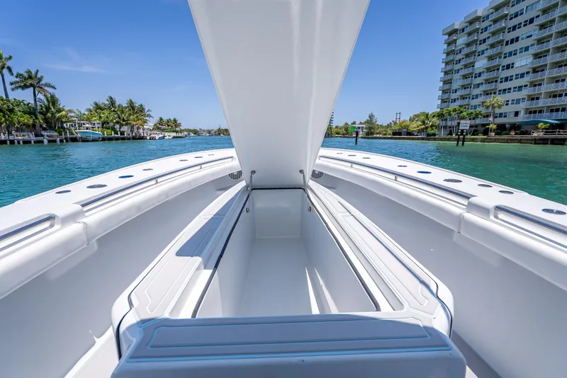 Slide: The Image of 2011 Revenge 35LT boat interior with open storage, docked near waterfront buildings and palm trees. - 14