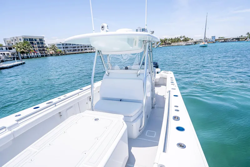 Slide: The Image of 2011 Revenge 35LT boat on calm water, featuring sleek design and spacious deck. - 16