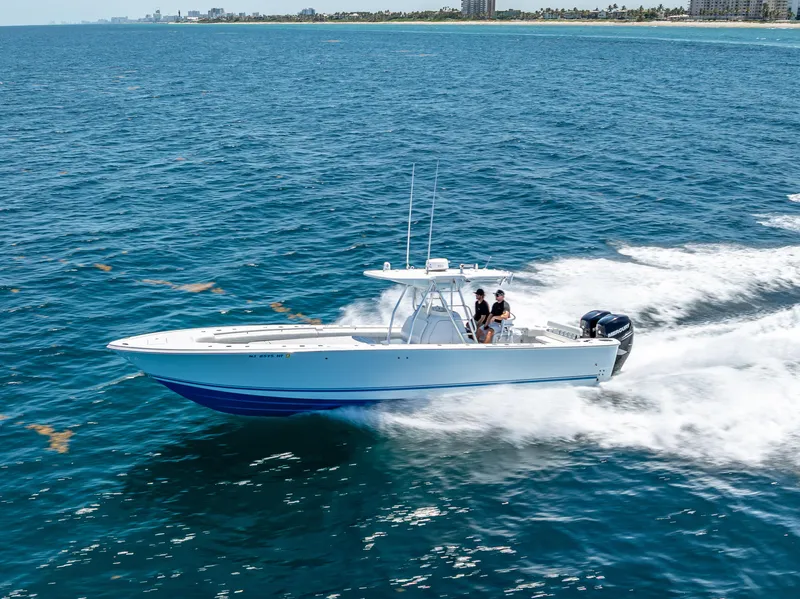 Slide: The Image of 2011 Revenge 35LT boat cruising on open water, clear blue sky in background. - 2