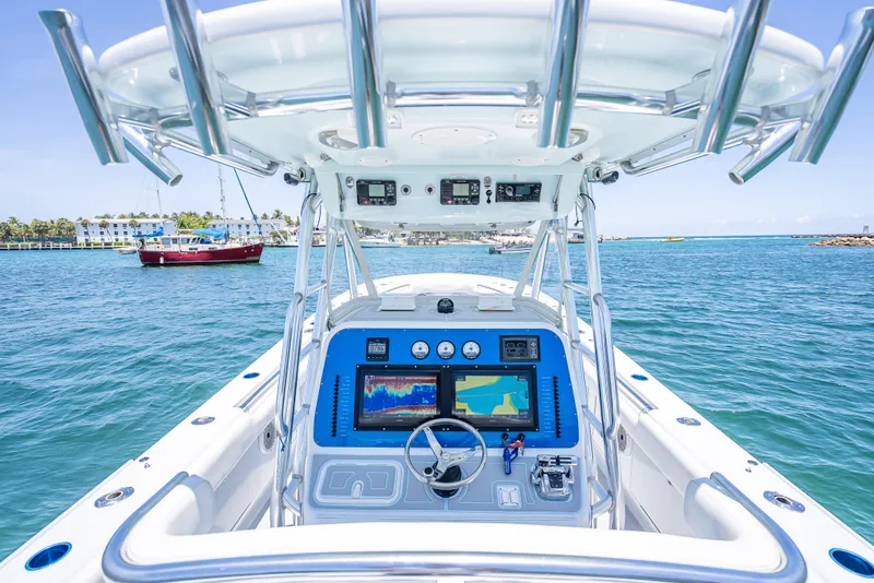 Slide: The Image of Center console of 2011 Revenge 35LT boat with navigation screens, steering wheel, and ocean view. - 22