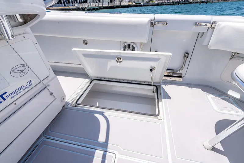 Slide: The Image of Open storage compartment on 2011 Revenge 35LT boat deck by the water. - 25