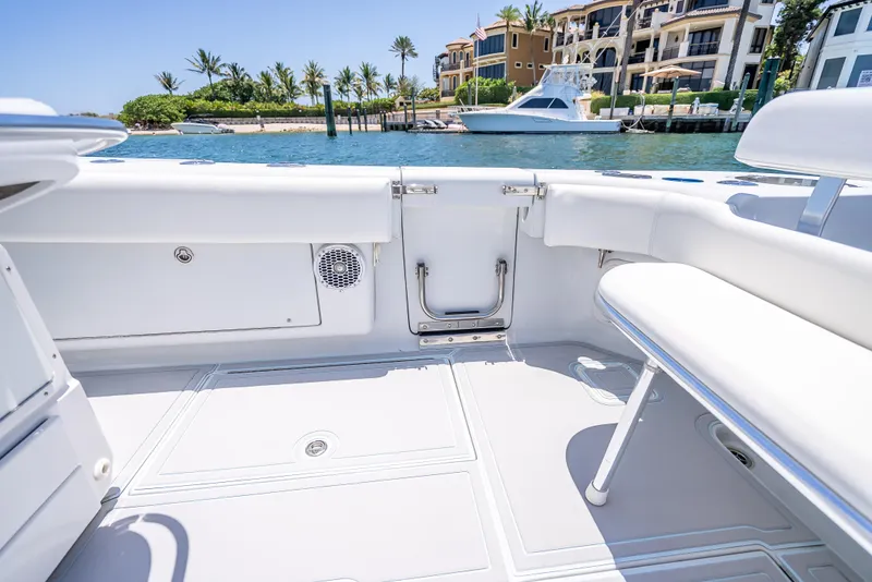 Slide: The Image of 2011 Revenge 35LT boat interior with white seating, docked near waterfront homes. - 26