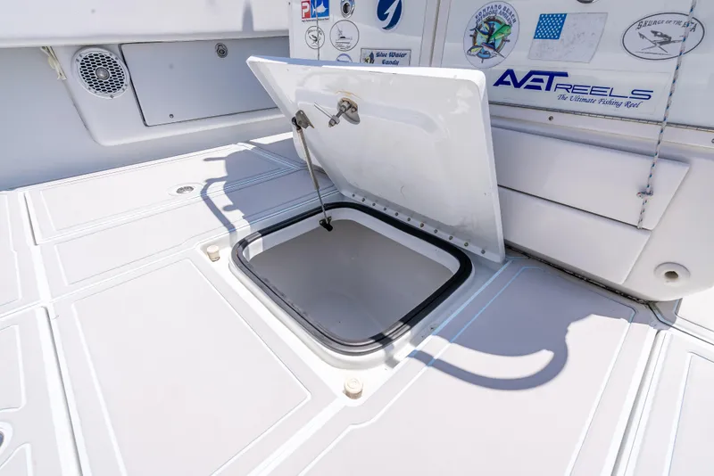 Slide: The Image of Open hatch on 2011 Revenge 35LT boat deck with visible storage compartment. - 27