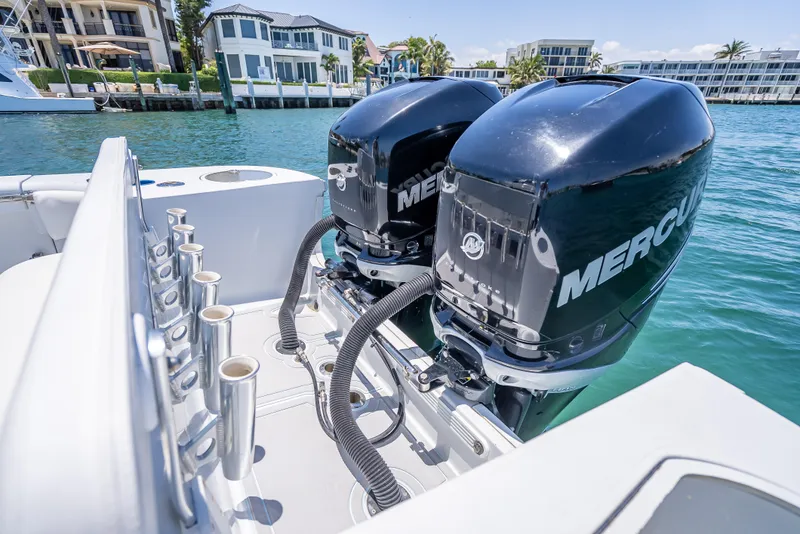 Slide: The Image of Twin Mercury outboard engines on a 2011 Revenge 35LT boat, docked near waterfront homes. - 29