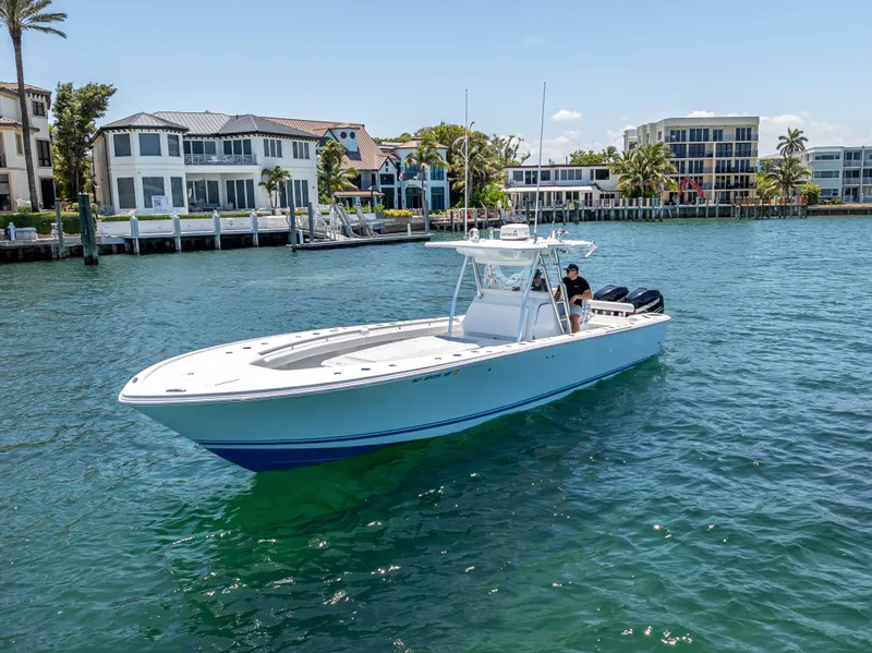 Slide: The Image of 2011 Revenge 35LT boat cruising on a sunny waterfront with luxury homes in the background. - 9