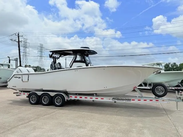 Slide: The Image of 2026 Tidewater 302 CC Adventure boat on trailer, under a clear blue sky. - 1