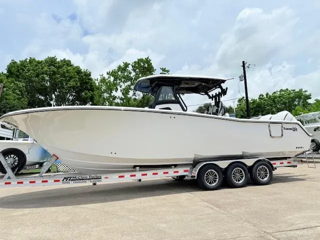 Slide: The Image of 2026 Tidewater 302 CC Adventure boat on a trailer, parked outdoors. - 13