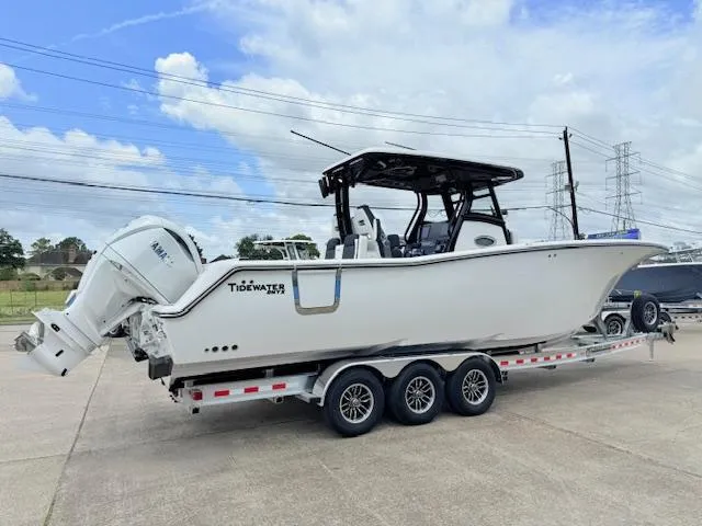 Slide: The Image of 2026 Tidewater 302 CC Adventure boat on a trailer, featuring dual engines and sleek design. - 2
